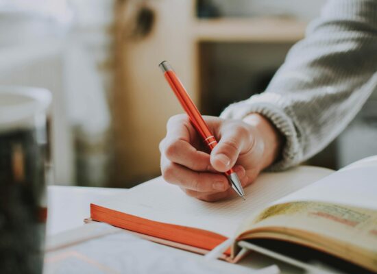 person holding orange pen